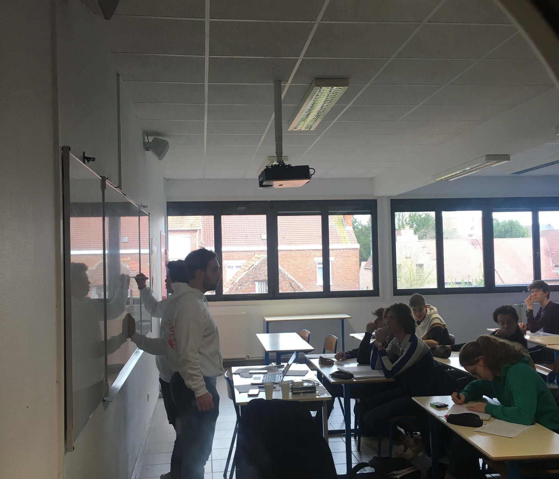 Cibleur au tableau devant une classe