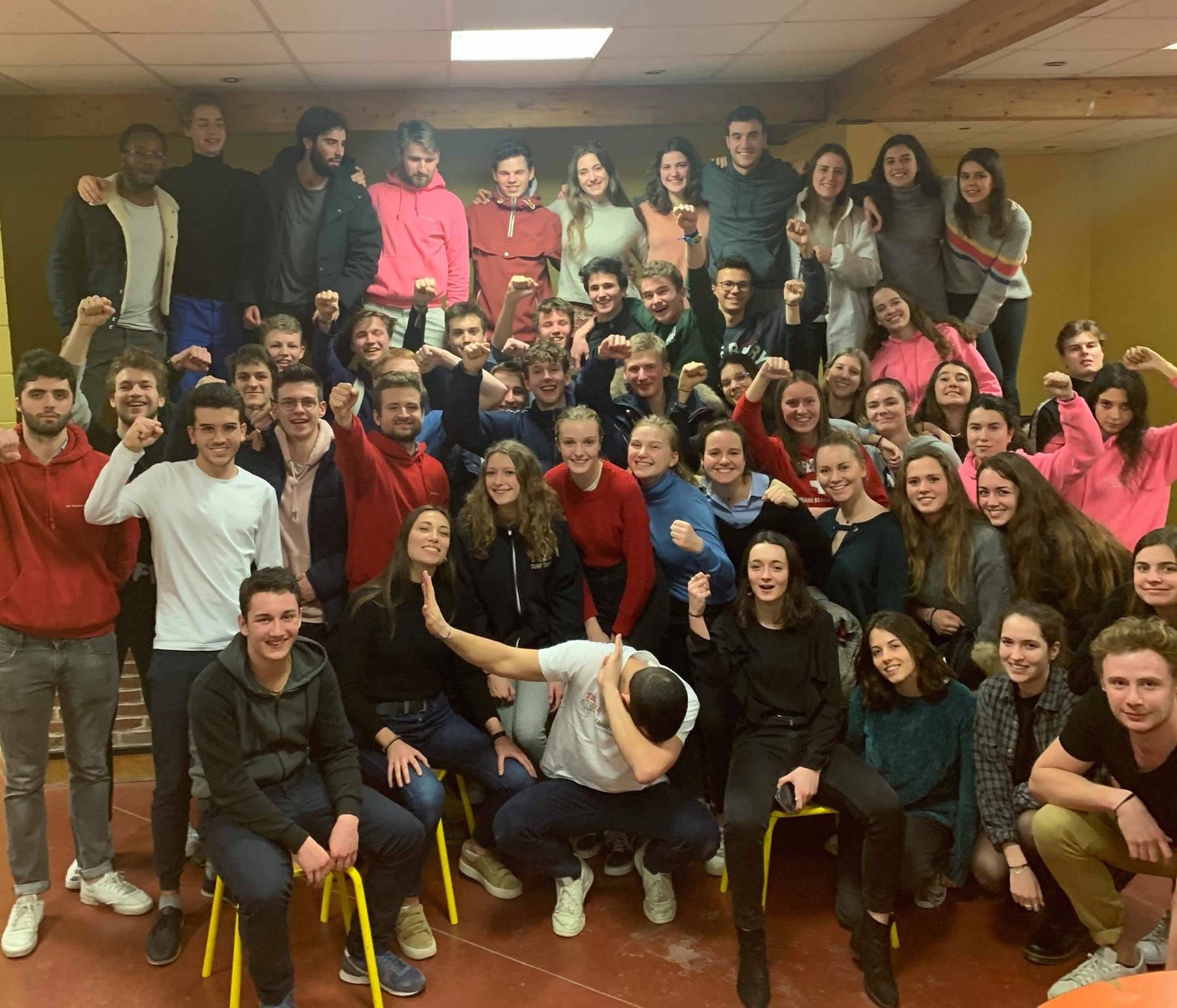Photo de groupe en salle, élèves et cibleurs poings levés